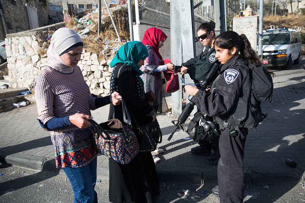Israelische Soldatinnen kontrollieren palästinensische Passantinnen in Ras al-Amud, Ost-Jerusalem, 2015. Foto: Activestills